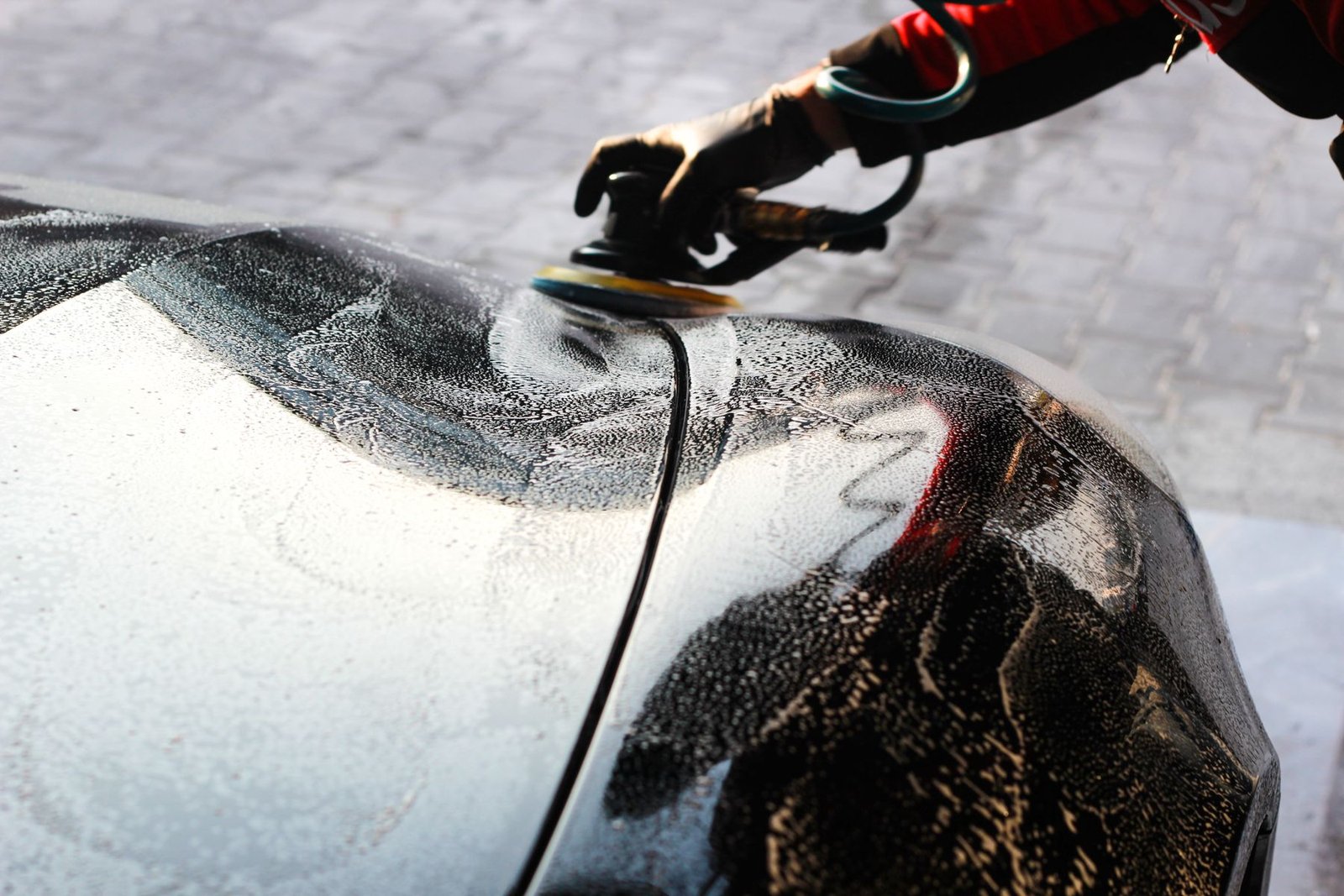 Professional detailer polishing a vehicle surface